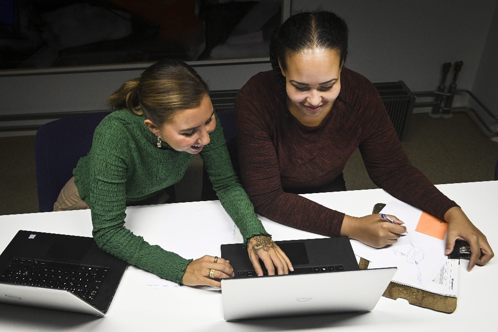 Kaksi nuorta naista tekee töitä tietokoneella